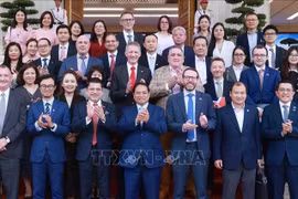 Премьер-министр Фам Минь Тьинь позирует для фото с представителями британского бизнеса. (Фото: ВИA)