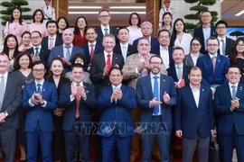 Премьер-министр Фам Минь Тьинь позирует для фото с представителями британского бизнеса. (Фото: ВИA)
