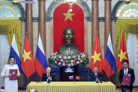 Тогдашний президент государства То Лам (второй справа) и президент России Владимир Путин стали свидетелями обмена подписанными документами между двумя странами по итогам переговоров в Ханое 20 июня 2024 года. (Фото: ВИA)