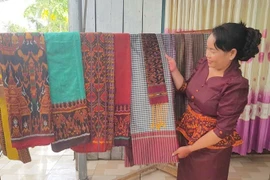 Госпожа Неанг Чань Ти, руководитель кооператива по ткачеству парчи народности Кхмер Ванзяо (община Анкы, провинция Анзянг), представляет уникальные изделия ремесленной деревни. Фото: dantocmiennui.baotintuc.vn