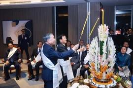 Генеральный секретарь ЦК КПВ То Лам (справа) и Генеральный секретарь ЦК НРПЛ, Президент Лаоса Тхонглун Сисулит принимают участие в традиционной лаосской церемонии завязывания нитей на запястьях, 5 февраля. (Фото: ВИА)