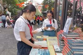 Ученики изучают книги на Книжной улице в Ханое. (Фото: ВИA)