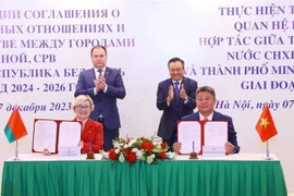 Премьер-министр Беларуси Роман Головченко (стоит слева) и председатель Народного комитета Ханоя Чан Ши Тхань стали свидетелями подписания программы сотрудничества по реализации договора о дружбе и сотрудничестве между Ханоем и Минском на 2023 год. (Фото: ВИA)