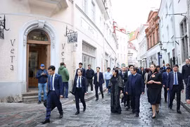 Премьер-министр Фам Минь Тьинь и его супруга знакомятся с историей Старого города Таллина. (Фото: ВИA)
