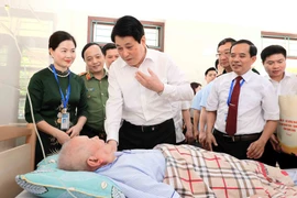Президент государства Лыонг Кыонг посещает и дарит подарки раненому солдату Нгуен Суан Маю, который проходит лечение в Центре ухода за инвалидами войны Зуйтьен. (Фото: ВИA)