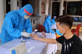 Медицинские работники проводят экспресс-тест на COVID-19 у людей, вернувшихся из районов эпидемии. (Фото: ВИА)