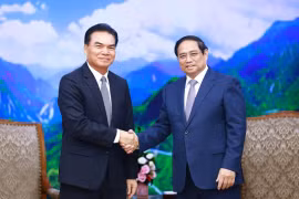 Премьер-министр Фам Минь Тьинь (справа) и министр планирования и инвестиций Лаоса, председатель комитет лаосско-вьетнамского сотрудничества Фет Фомфифак в Ханое 19 августа (Фото: ВИA).