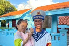 Солдат Чыонгша с маленькой девочкой на острове Чыонгша (Фото: Vietnam+)
