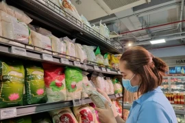 Местный житель покупает рис по стабилизированной цене в супермаркете в городе Хошимин. (Фото: ВИА)