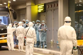 Медработники проводят дезинфекцию и медицинскую проверку вьетнамских граждан, вернушихся из Китая. (Фото: Зыонг Зянг/ВИА)