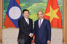 Премьер-министр Нгуен Суан Фук (справа) приветствует своего лаосского коллегу Тонглуна Сисулита (Фото: ВИА)