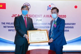 Президент JICA г-н Китаока Шиничи (слева) вручил Почетную грамоту директору Национального института гигиены и эпидемиологии. (Фото: корр./ Vietnam +)
