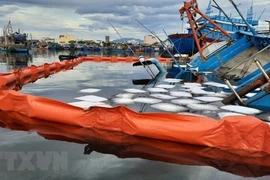 Ликвидация инцидента с разливом нефти на море после того, как рыболовное судно затонуло в рыболовном порту Тхокуанг в городе Дананг. (Фото: опубликовано ВИА)