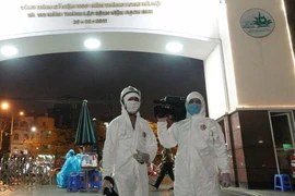 Фотокорреспондент Зыонг Жанг на мероприятии по проведению карантины и дезинфекции больницы Батьмай вечером 28 марта 2020 года. (Источник: ВИА)