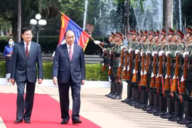 Генеральный секретарь, президент Лаоса Тонглун Сисулит и президент Нгуен Суан Фук осматривают почетный караул. (Фото: ВИА)