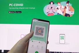 Людей просят использовать мобильное приложение PC-COVID, когда они принимают участие в социально-экономической деятельности в Хошимине. (Фото: ВИА)