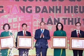 Президент Нгуен Суан Фук (в центре) вручает звание «Заслуженный учитель» 12 преподавателям сельскохозяйственной академии Вьетнама на церемонии 20 ноября (Фото: ВИA)