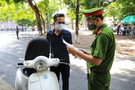 При выходе на улицы жители Ханоя обязаны предъявить пропуск, выданный работодателями. (Фото: ВИА)