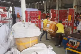 Рабочие Почты Вьетнама загружают посылки в распределительном центре в городе Хошимин. (Фото: ВИА)