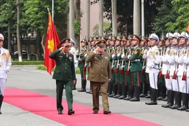 Министр национальной обороны Фан Ван Жанг и министр Революционных вооруженных сил Кубы Альваро Лопес Миера принимают ряды почетного отряда Вьетнамской народной армии. (Фото: ВИА)