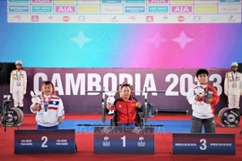Тяжелоатлет Данг Тхи Линь Фыонг (в центре) на 12-х Паралимпийских играх АСЕАН. (Фото: ВИА) Ле Ван Конг получает золот