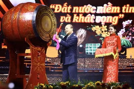 Президент государства Нгуен Суан Фук бьет в барабан в знак начала программы. (Фото: ВИА)