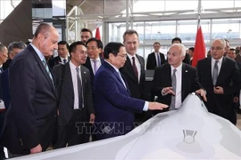 Премьер-министр Фам Минь Тьинь рассматривает модель самолета на заводе Turkish Aerospace Industries (TAI) (Фото: ВИA)