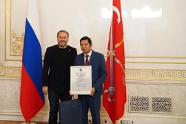 Нгуен Куок Хунг (справа), директор фонда “Традиции и дружба”, получает почетную грамоту Законодательного собрания Санкт-Петербурга (Фото: ВИA)