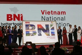 Хо Куанг Минь, президент BNI Vietnam (7-й слева), передает фотографию с подписями предпринимателей представителю Управленияа туризма города Дананг. (Фото: ВИА)