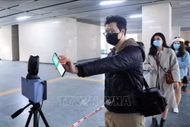 Люди используют приложение PC-COVID для сканирования QR-кодов. (Фото: Фам Киен/ВИА)
