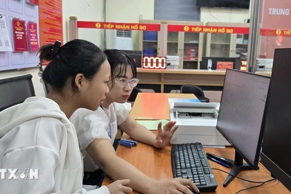 Госпожа Чан Тхи Ким Ньунг, специалист квартала Фулиен, Хайфон, помогает гражданам направлять документы для регистрации брака через Национальный портал государственных услуг. (Фото: ВИА)