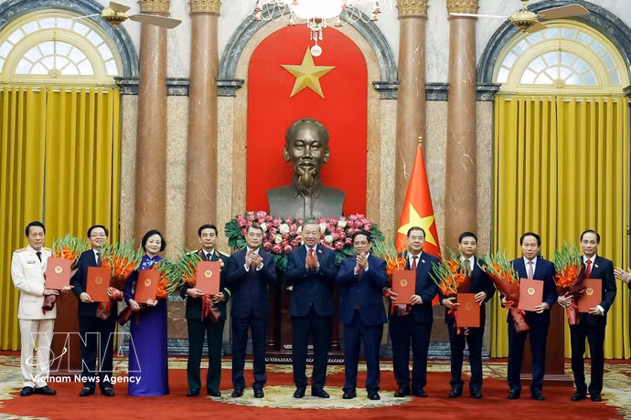 Генеральный секретарь, Президент государства То Лам вручает решения о назначении шести заместителей Премьер-министра, а также Министра общественной безопасности и Министра иностранных дел. Премьер-министр Ле Минь Хынг и бывший Премьер-министр Фам Минь Тьинь преподносят цветы и поздравляют. (Фото: ВИА)