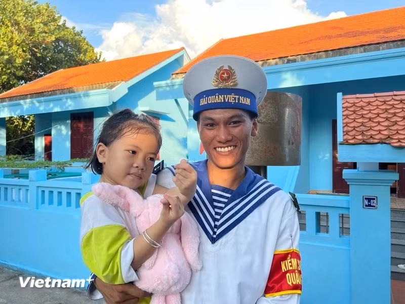 Солдат Чыонгша с маленькой девочкой на острове Чыонгша (Фото: Vietnam+)