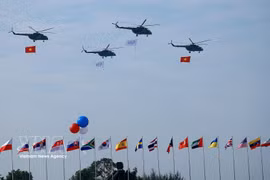 Группа вертолётов с государственными флагами Вьетнама выполняет показательный полёт на церемонии открытия Международной выставки оборонной промышленности Вьетнама 2024 года. Фото: ВИА