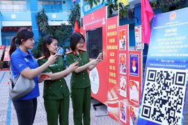 Молодые избиратели Хошимина сканируют QR-код для участия в онлайн-викторине по Закону о выборах. (Фото: ВИА)