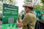 Мужчина сканирует QR-код платформы электронной коммерции VinachemMart во время запуска 10 мая. (Фото: ВИA)