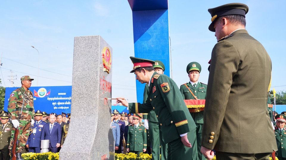 Генерал армии Тиа Сеиа, заместитель премьер-министра, министр национальной обороны Королевства Камбоджа, наблюдает, как генерал армии Фан Ван Жанг, министр национальной обороны Вьетнама, наносит краску на пограничный столб №171 в международном пункте пропуска Мокбай (провинция Тэйннинь). (Фото: ВИА)