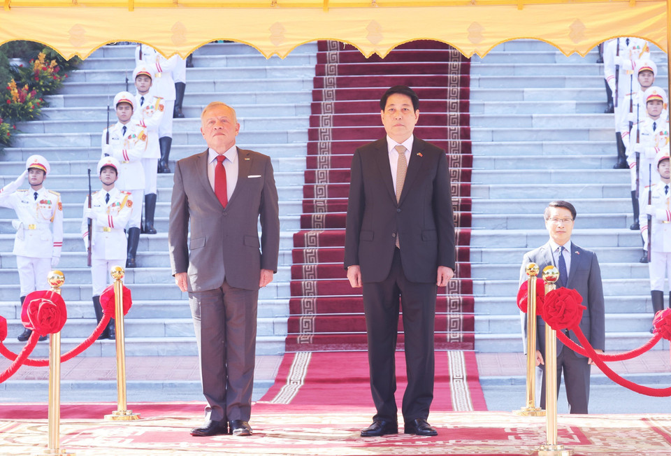 Президент государства Лыонг Кыонг и Король Иордании Абдалла II ибн аль-Хусейн стоят на трибуне почёта, слушая исполнение Государственных гимнов двух стран. (Фото: ВИА)