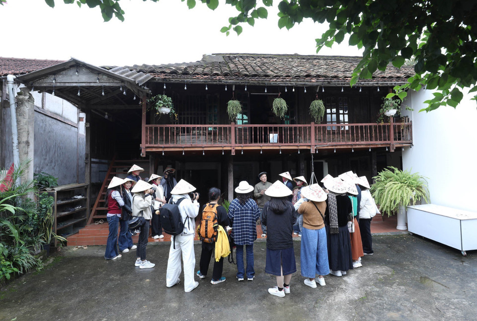 Туристы знакомятся с традиционными домами на сваях в хомстее Зыонг Конг Чай, расположенном в деревне общественного туризма Куиньшон, община Бакшон, провинция Лангшон. (Фото: ВИА)