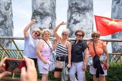 Иностранные туристы с удовольствием делают фото на Золотом мосту в Дананге (Фото: ВИА)