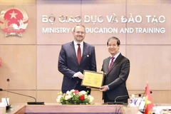 Министр Нгуен Ким Шон вручил памятный знак «За заслуги в сфере образования» заместителю министра Константину Могилевскому (Фото: MOET)