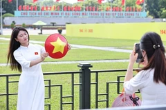 Жители фотографируются на площади Бадинь накануне большого праздника