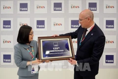 Заместитель гендиректора ВИА Доан Тхи Туэт Ньунг вручает подарок гендиректору ТАСС Андрею Кондрашову (Фото: ВИА)
