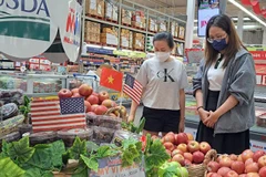 Покупатели выбирают американские яблоки в супермаркете в Хошимине (Фото: nld.com.vn)