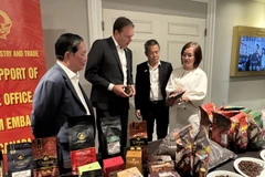 Торговый советник Чан Тху Куинь (справа) знакомит с продукцией высококачественного вьетнамского кофе председателя Канадской ассоциации кофе (второй слева) (Фото: ВИА)
