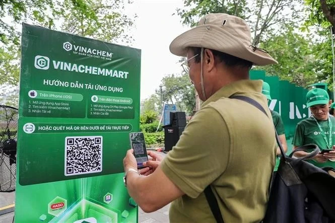 Мужчина сканирует QR-код платформы электронной коммерции VinachemMart во время запуска 10 мая. (Фото: ВИA)