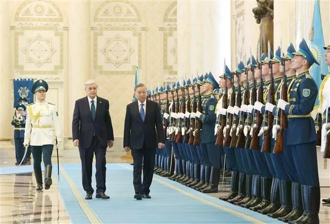 Президент Казахстана Касым-Жомарт Токаев и генеральный секретарь ЦК КПВ То Лам (справа) обходят строй почетного караула (Фото: ВИA)