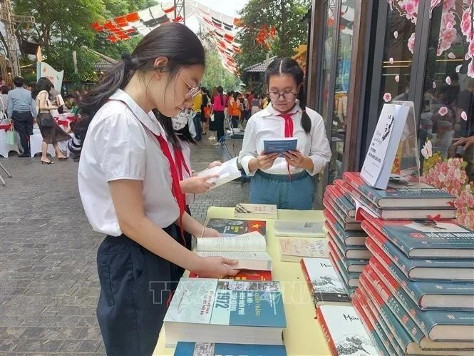 Ученики изучают книги на Книжной улице в Ханое. (Фото: ВИA)