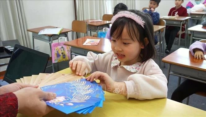 Май Чи, пятилетняя ученица языковой школы Dai Viet, радуется, когда получает счастливые деньги - традиция вьетнамского народа в Новый год по лунному календарю (Фото: ВИA)