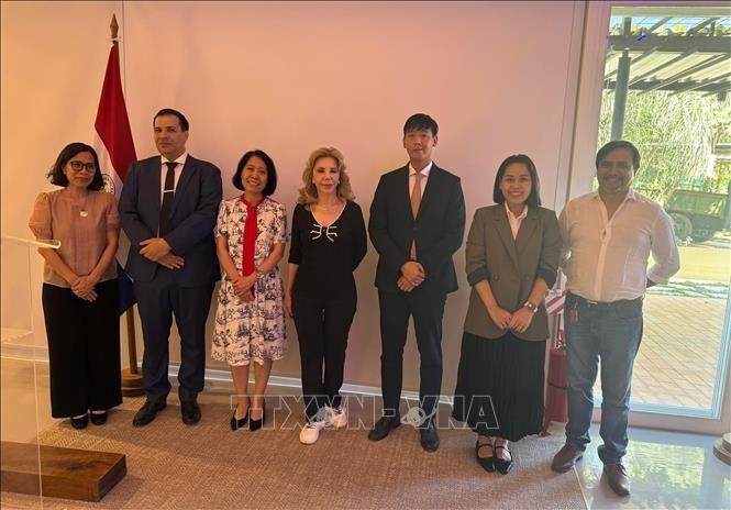 Vietnamese Ambassador to Argentina and Paraguay Ngo Minh Nguyet (third from left), Paraguayan Minister of the Secretariat of Linguistic Policies Javier Viveros (second from left), and Vietnam's Honorary Consul in Paraguay María Del Carmen Pérez (C) pose for a photo with delegates. (Photo: VNA) 